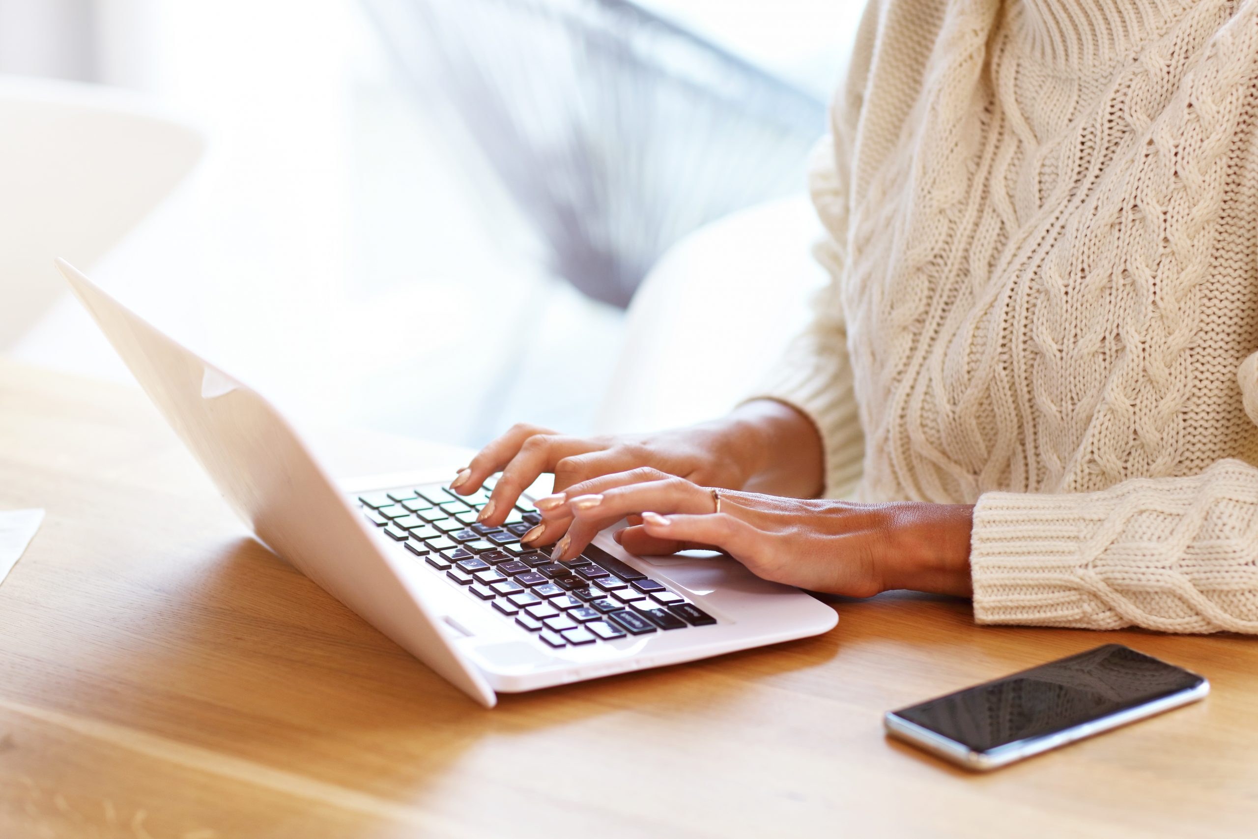 Adult woman wearing warm sweater and working at home one autumn day